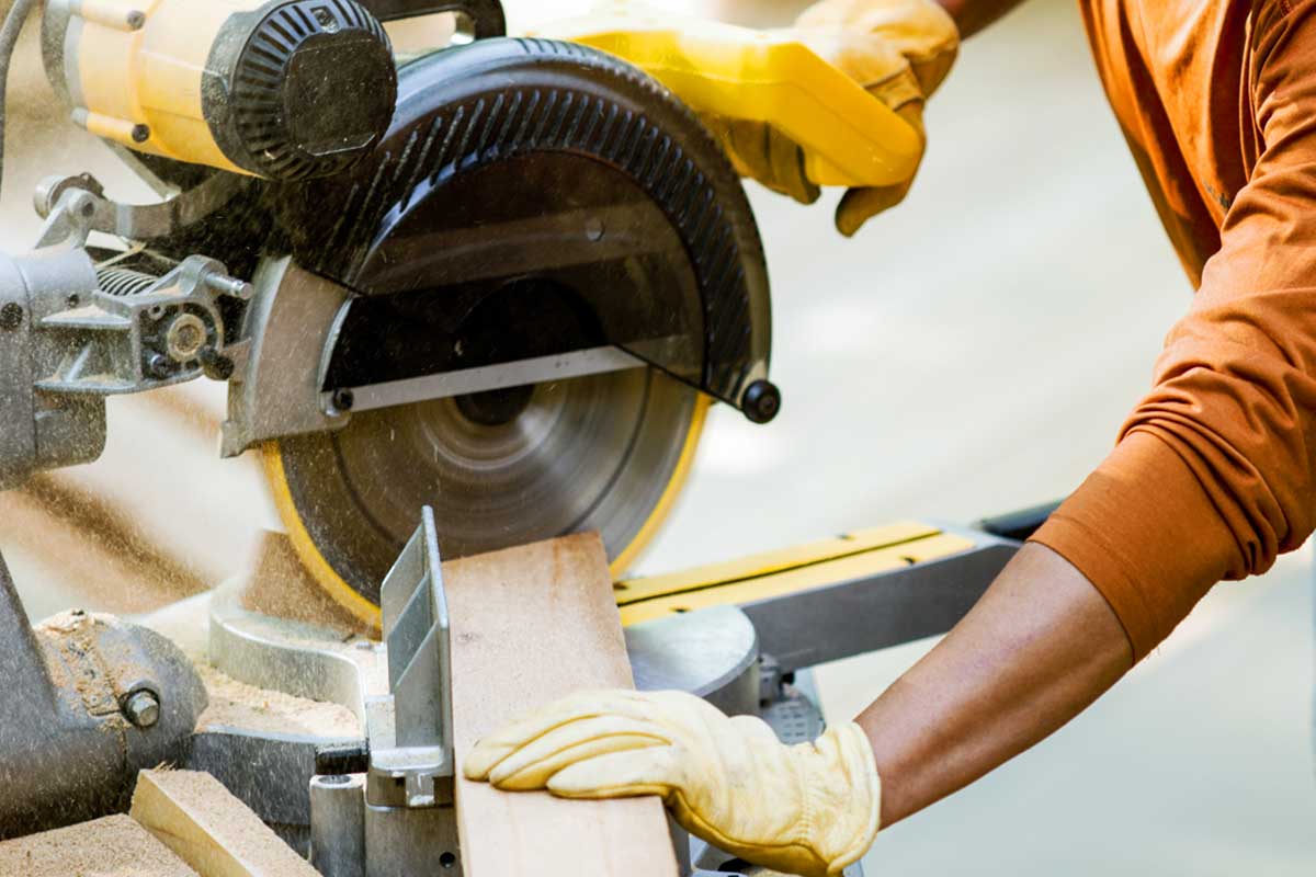 Person cutting wood with a miter saw